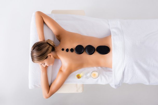 Ansicht von oben: junge Frau bekommt Hot-Stone-Massage im Wellness-Salon - Foto, Bild