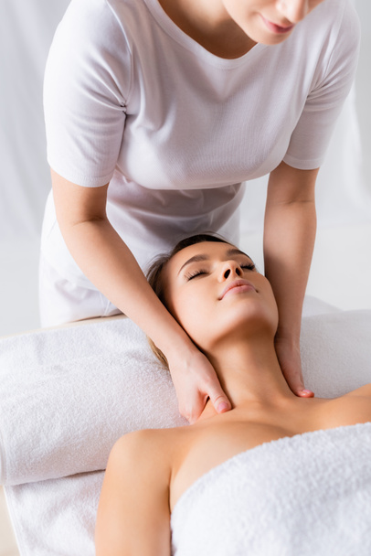 masseuse faisant massage du cou au client heureux dans le salon de spa  - Photo, image