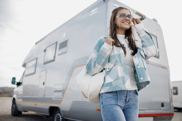 Young happy smiling woman with bag near caravan - Photo, Image