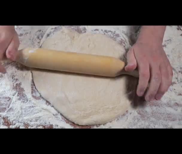 Frau rollt den Teig mit Nudelholz in Nahaufnahme aus. Zeitraffer - Filmmaterial, Video