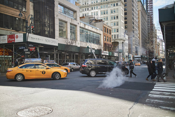 a yellow taxi driving in new york street - 写真・画像
