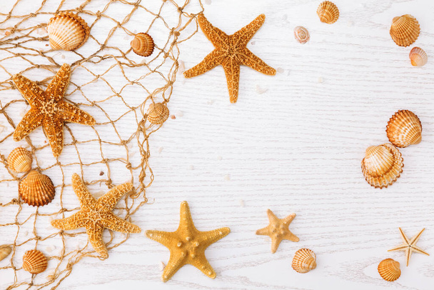 Летнее время с морской раковиной и морской звездой на белом деревянном фоне. - Фото, изображение