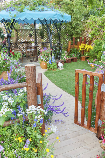 Lush landscaped backyard flower garden with wooden gate - Photo, Image