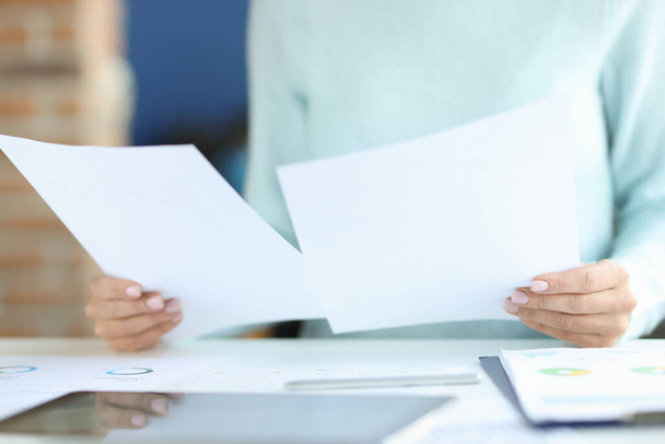 Female hands hold documents over work table - Fotografie, Obrázek