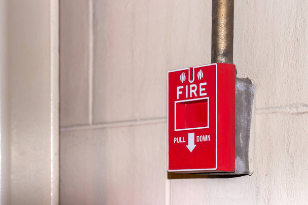 Ręczna stacja ściągająca umieszczona na ścianie dla systemu sygnalizacji pożarowej w przypadku pożaru miała miejsce w fabryce. Jest to sprzęt do bezpieczeństwa w miejscu pracy w razie pożaru. - Zdjęcie, obraz