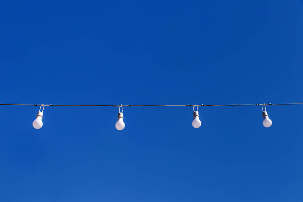 LED-Licht Blub in Reihe auf blauem Himmelhintergrund - Foto, Bild