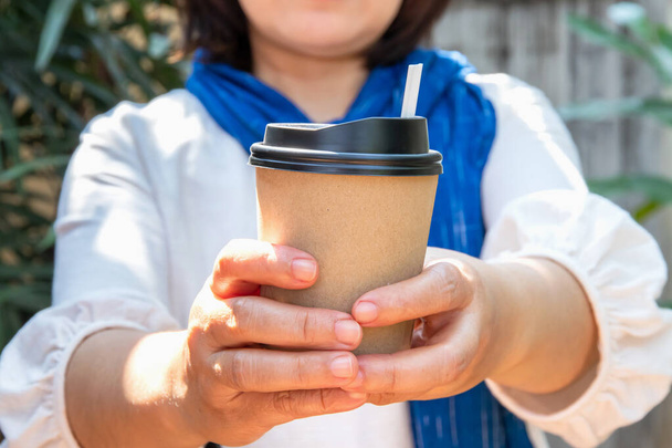 Női kéz papír csésze kávé elviszi, papír kávéscsésze női kézben tökéletes manikűr - Fotó, kép