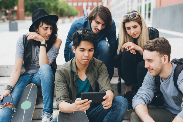 Grupo de amigos multiétnicos millennials usando smartphone viciado em tendências tecnológicas seguindo e conversando e assistindo vídeos - Foto, Imagem