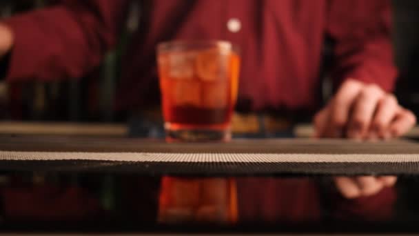 De barman serveert een Negroni cocktail op de bar. Langzame beweging. - Video