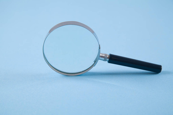 Magnifier on an isolated blue background. - Photo, Image