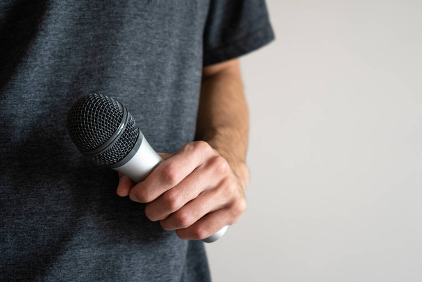 Man holding a microphone and preparing to give a speech. Close-up shot.  - Foto, Bild