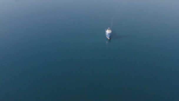 Deniz dalgaları üzerinde yüzen konteynırları olan ultra büyük mavi kargo gemisinin hava manzarası. - Video, Çekim