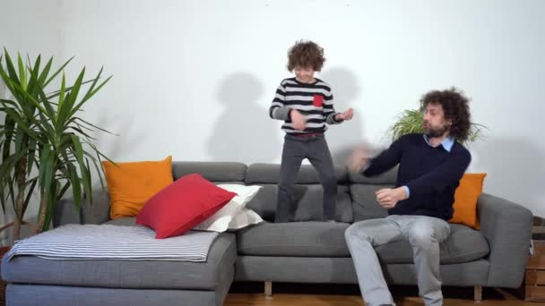 Gelukkige grappige en gekke familie in appartement vader en zoon muziek spelen zonder muziekinstrumenten tijdens Covid-19 Coronavirus lockdown quarantaine huis - levensstijl in de woonkamer - Video