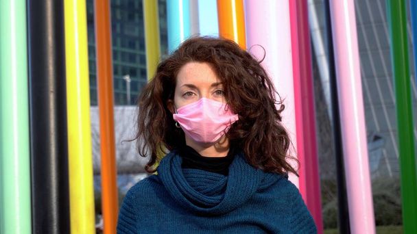 Italy, Milan - Cute caucasian lady girl 30 years old portrait outdoor with pink mask on the face during Covid-19 Coronavirus lockdown - Foto, afbeelding
