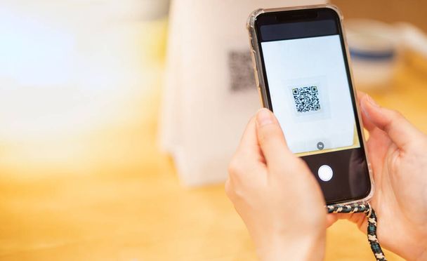 Female hand scanning the QR code with mobile phone for order foods and pay at the restaurant for the new technology e-wallet and e-payment. - Foto, Imagen