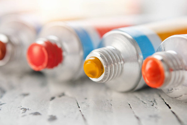 Closeup of professional paints in tubes in different colors. Selective focus on tube with yellow paint. - Zdjęcie, obraz