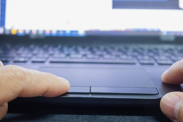 doigt touchant sur le pavé tactile pour la recherche de données dans l'ordinateur portable - Photo, image
