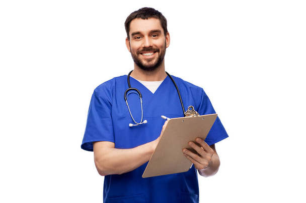 male doctor writing medical report on clipboard - Zdjęcie, obraz