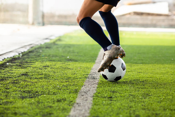 Die Füße des Fußballers springen und kontrollieren den Ball auf dem Kunstrasen. - Foto, Bild