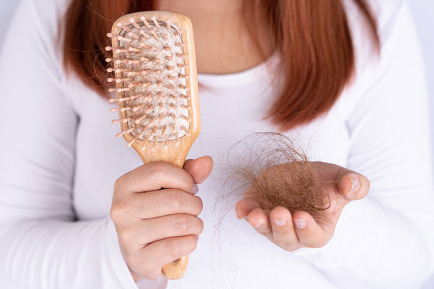 Hair fall problem, closeup hand holding comb and problem hair. Healthcare medical or daily life concept. - Photo, Image