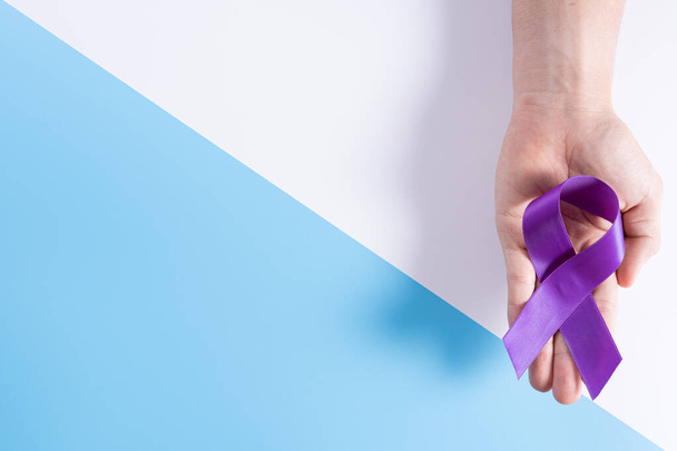 World cancer day, hands holding purple ribbon on with and blue background with copy space for text. Healthcare and medical concept. - Foto, immagini