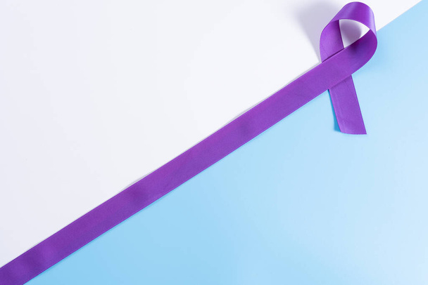 World cancer day, purple ribbon on with and blue background with copy space for text. Healthcare and medical concept. - Foto, imagen