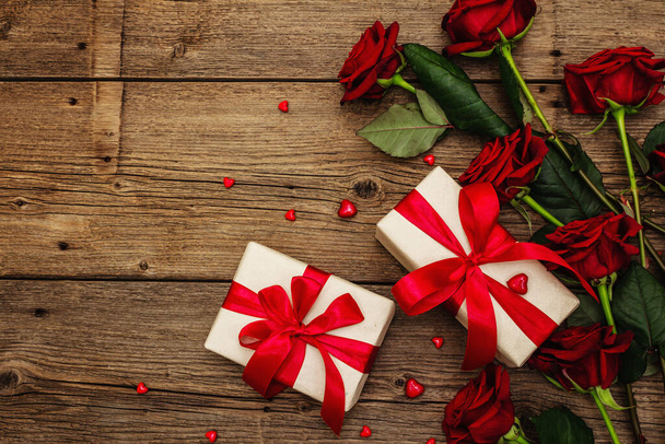 Valentine tło kartki z pudełkami, świeże burgundowe róże i różne serca. Drewniany stół. Koncepcja ślubna lub urodzinowa, miejsce na tekst, leżące płasko - Zdjęcie, obraz