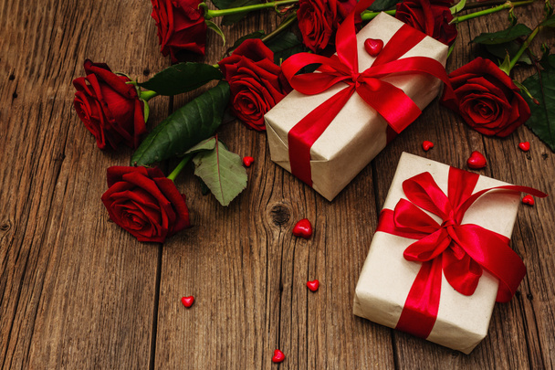 Valentin üdvözlőkártya háttér ajándékdobozok, friss burgundi rózsák és válogatott szív. Vintage fa asztal. Esküvő vagy születésnap koncepció, szöveges hely, lapos fektetés - Fotó, kép