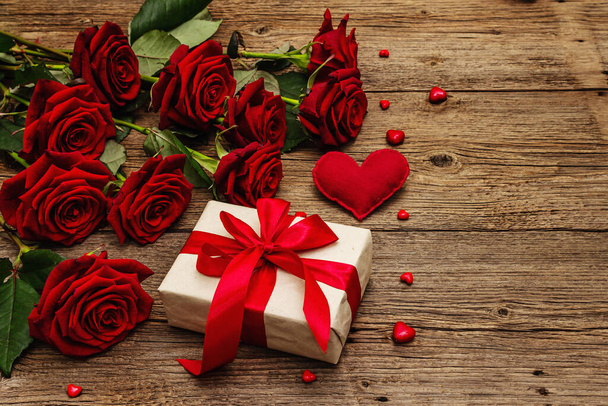 Valentijn wenskaart achtergrond met geschenkdozen, verse Bourgogne rozen en diverse harten. Vintage houten tafel. Bruiloft of Verjaardag concept, plaats voor tekst, plat lay - Foto, afbeelding