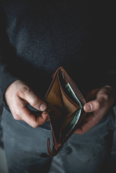 An Empty wallet in the hands of a young man - Fotó, kép
