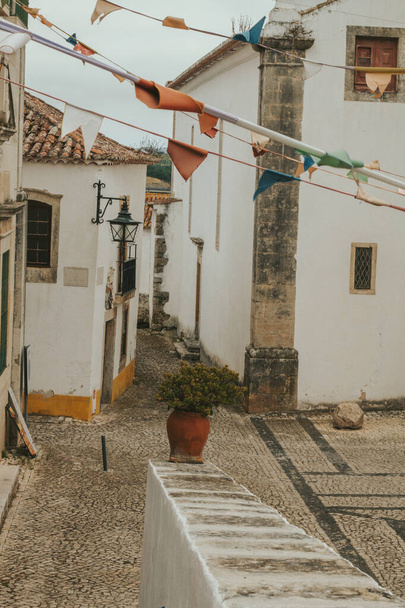 OBIDOS, PORTUGAL - 08-09-2020: Сувенирные магазины и красочные узкие улочки средневекового португальского города обидос, туристическая достопримечательность в центральной Португалии. известный своей архитектурой - Фото, изображение