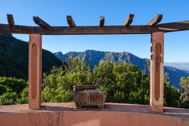 alto ponto de vista na ilha da madeira com um alpendre de pedra enquadrando as montanhas no backgroun em um dia de céu azul claro - Foto, Imagem