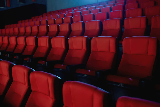 Close up shot of interior of cinema auditorium with lines of red chairs - Fotoğraf, Görsel