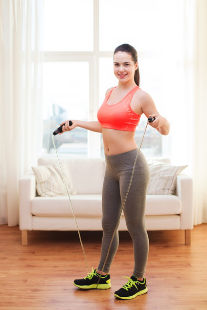 Smiling teenage girl with skipping rope at home - Photo, image