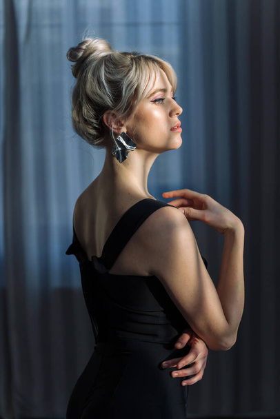 Close up studio portrait of a pretty blonde woman in black top, looking at the camera. - Fotó, kép