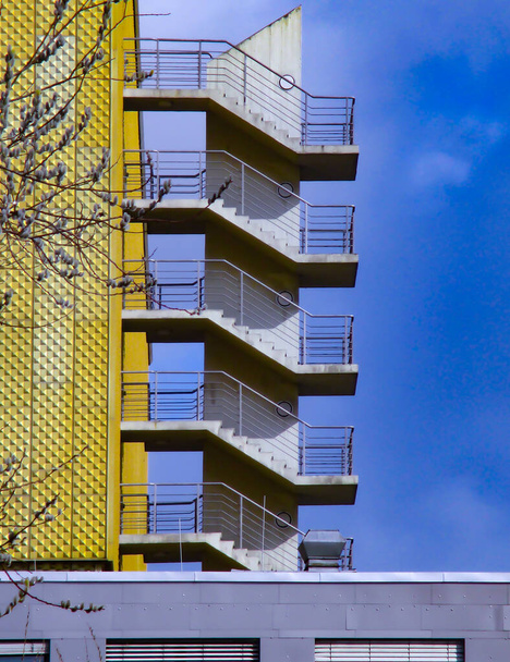Современное здание, бетонная пожарная лестница над голубым небом, внешняя структура - Фото, изображение