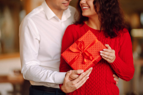 Exchange of gifts.  Young couple in love offering gift to each other for valentine day or birthday. Romantic day. Winter holidays. - Фото, изображение