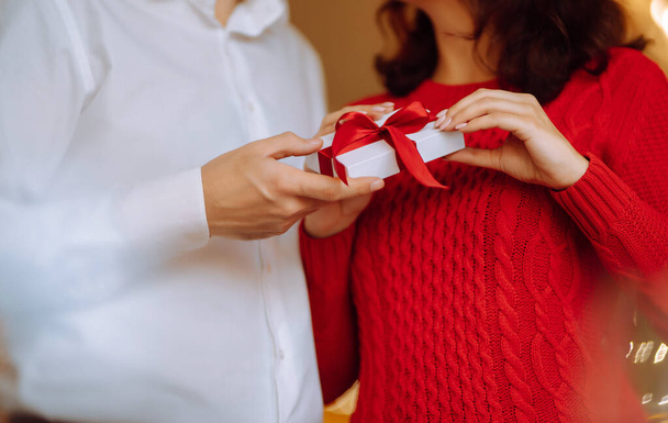 Exchange of gifts.  Young couple in love offering gift to each other for valentine day or birthday. Romantic day. Winter holidays. - Foto, afbeelding