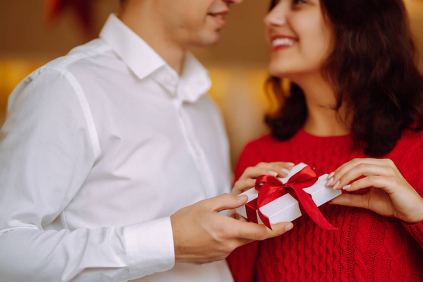 Exchange of gifts.  Young couple in love offering gift to each other for valentine day or birthday. Romantic day. Winter holidays. - Foto, Bild
