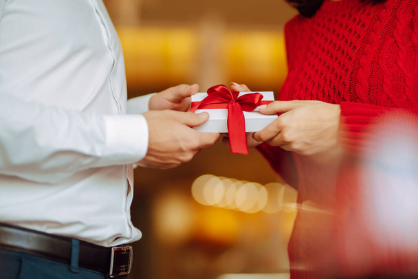 Exchange of gifts.  Young couple in love offering gift to each other for valentine day or birthday. Romantic day. Winter holidays. - Foto, imagen