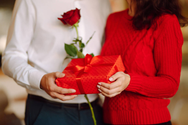 Exchange of gifts.  Young couple in love offering gift to each other for valentine day or birthday. Romantic day. Winter holidays. - Fotó, kép