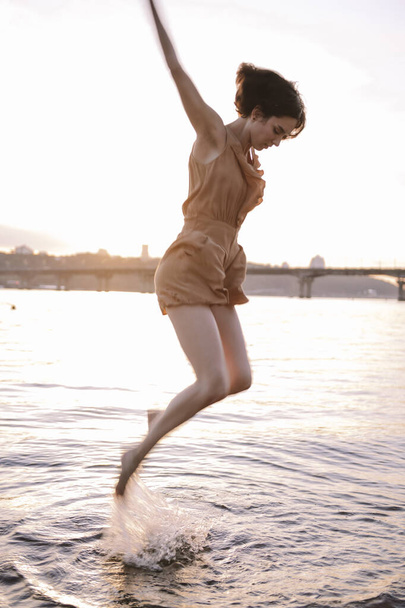 young woman posing and yoga dancing near beach at sunset - Fotografie, Obrázek