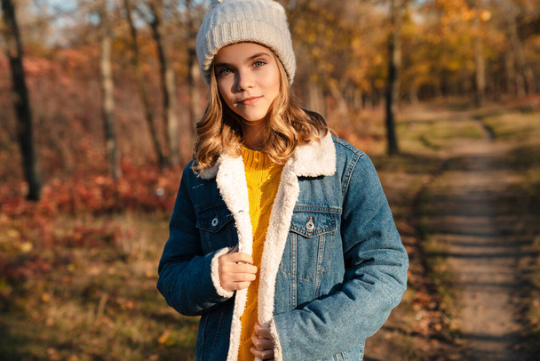 Image of young pretty girl walking outdoors in autumn park - Foto, imagen