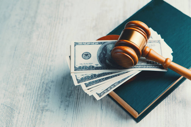 Judge gavel with dollars and law books - Фото, изображение