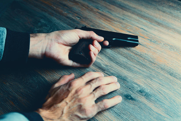 man holding a gun in his hands. - Фото, изображение