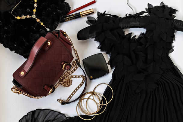 Black with gold flatlay on a white background. Party clothing, accessories,bag and cosmetics. Holiday preparation concept. - Fotó, kép