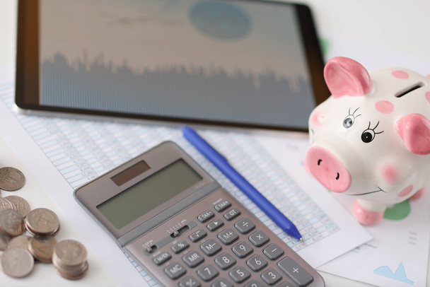 Na mesa está a calculadora porco e tablet com moedas - Foto, Imagem