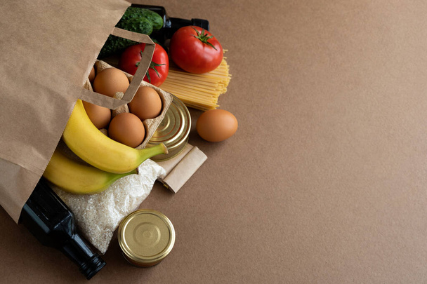 Χάρτινη σακούλα με προμήθειες τροφίμων σε χαρτονένιο φόντο. Παράδοση τροφίμων, mobile παραγγελία app concept. Αντιγραφή χώρου για κείμενο - Φωτογραφία, εικόνα