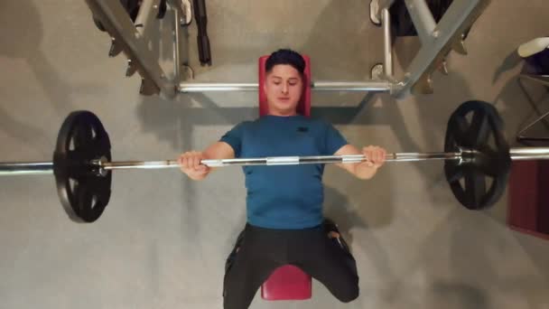 Young fit Latin Man In Gym Exercising Chest On The Bench Press. Musculação, motivação, estilo de vida ativo e saudável. Vista superior, zoom aéreo desligado. - Filmagem, Vídeo
