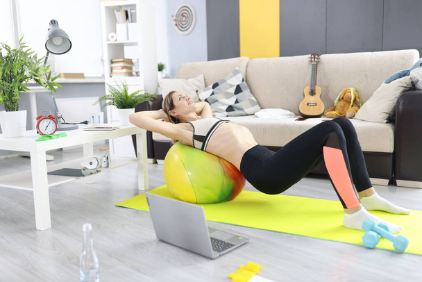 Woman lies on fitball and does abdominal exercises - Foto, Imagem
